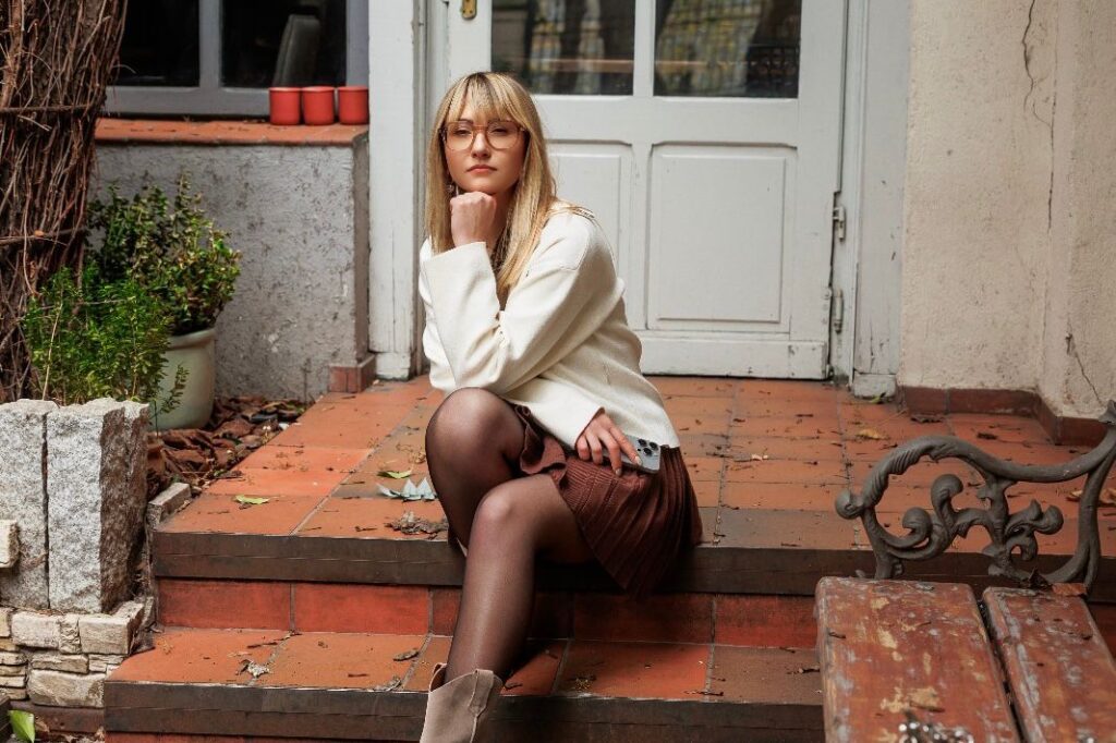 Patrycja siedząca na ganku w jesiennym klimacie w pełni skupiona